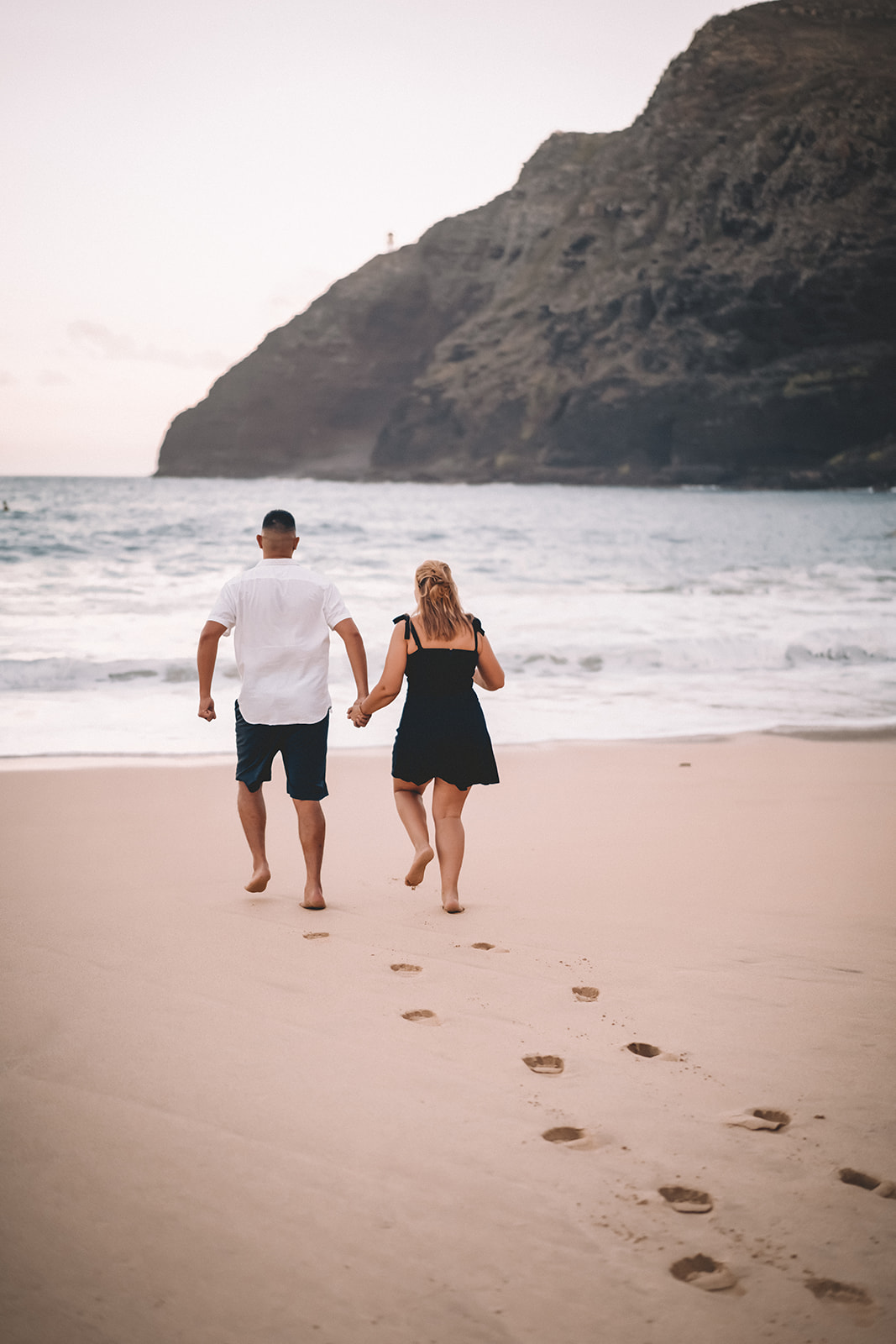 man and woman running into pacific ocean hawaii
