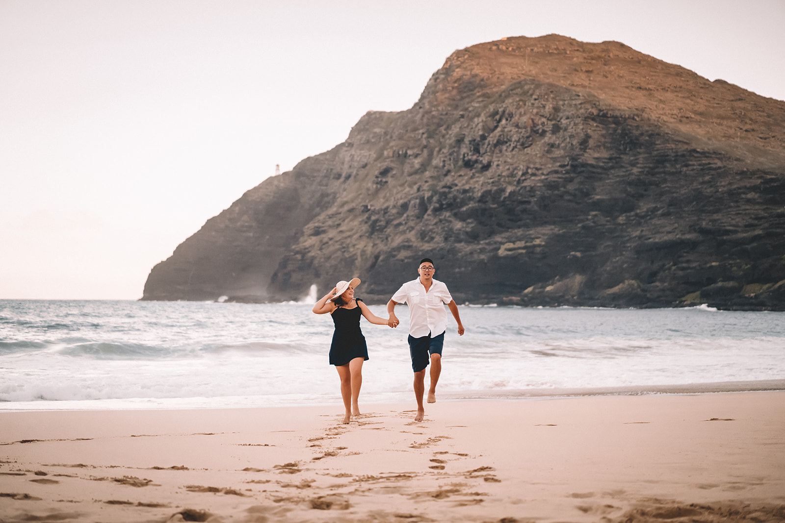 man and woman running out of water makapuu beach