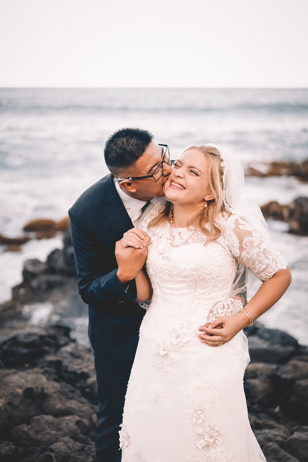 man kissing bride to be giggling makapuu beach