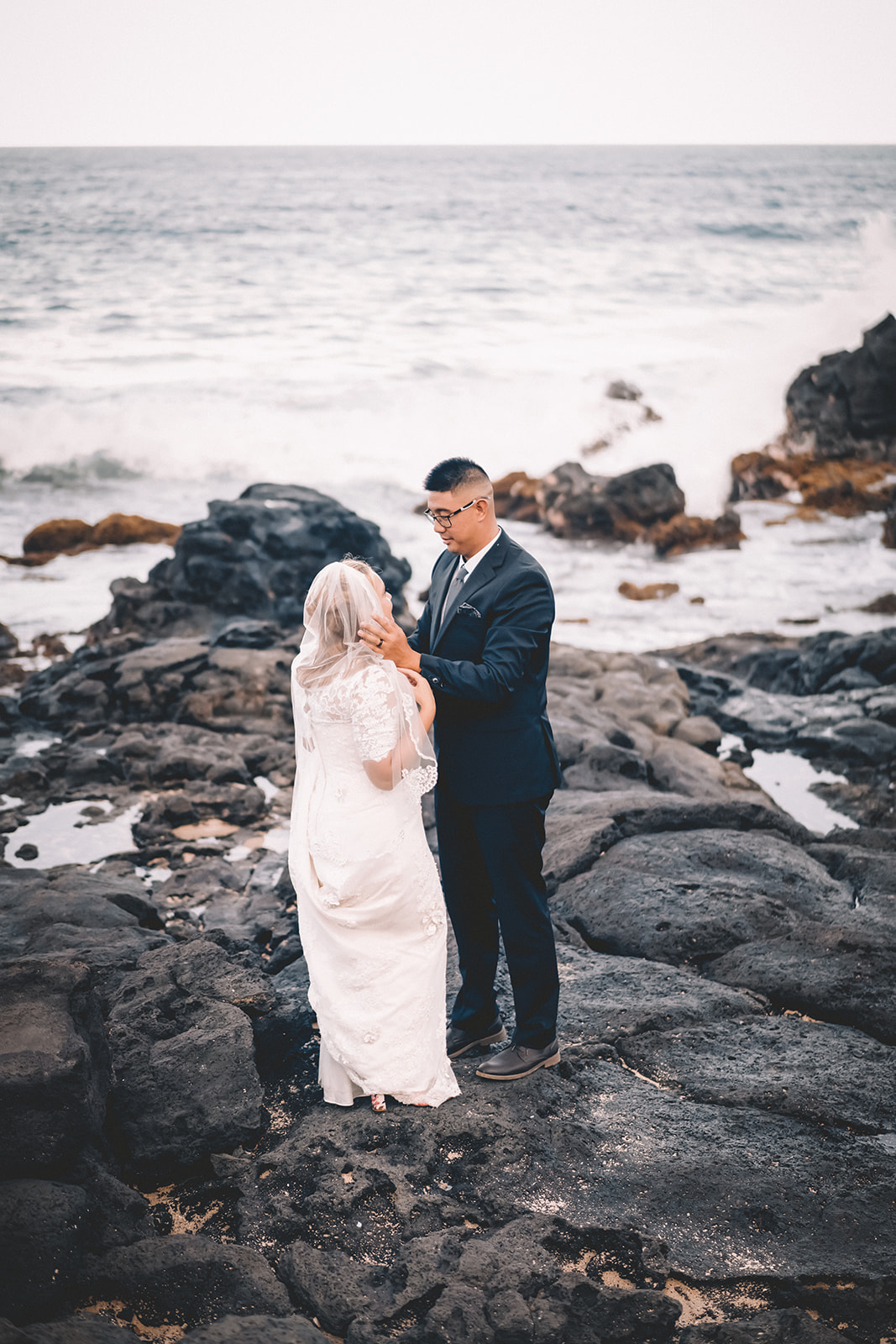 groom caressing face wife to be makapuu beach