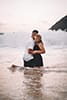 woman and man kneeling hugging at shoreline
